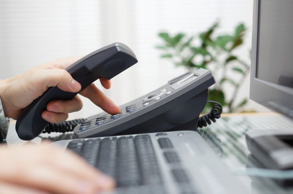 Geschäftsmann wählt eine Telefonnummer im Büro